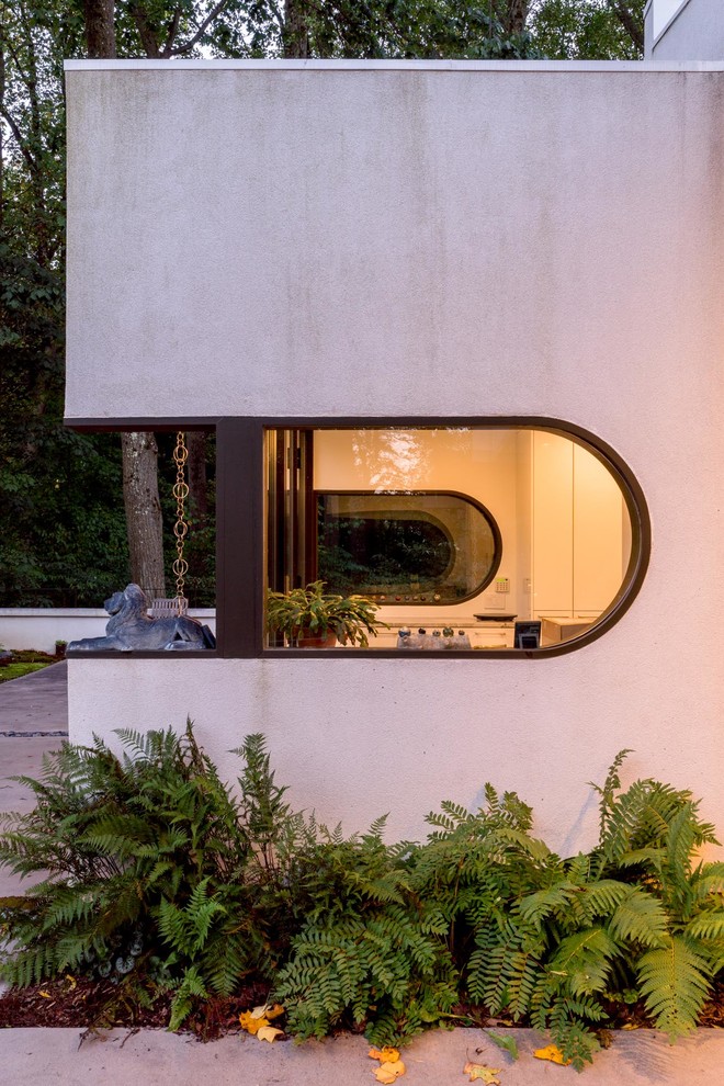 Стильный дизайн: белый дом в стиле модернизм с облицовкой из цементной штукатурки - последний тренд