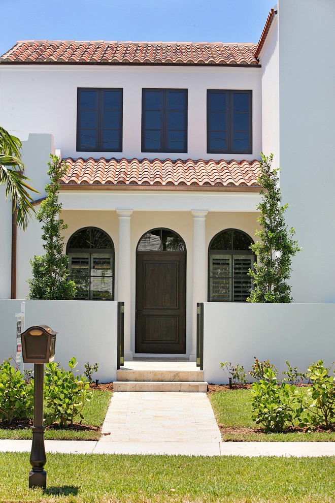 Photo of a large and white mediterranean two floor render house exterior in Miami.