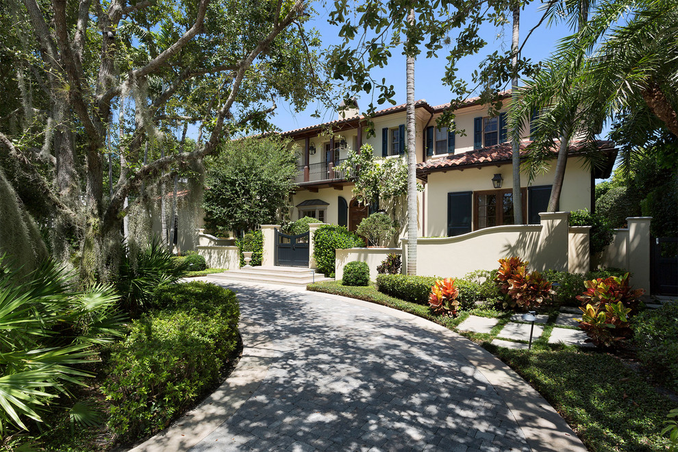 Mittelgroßes, Zweistöckiges Mediterranes Einfamilienhaus mit Betonfassade, beiger Fassadenfarbe, Walmdach und Schindeldach in Miami