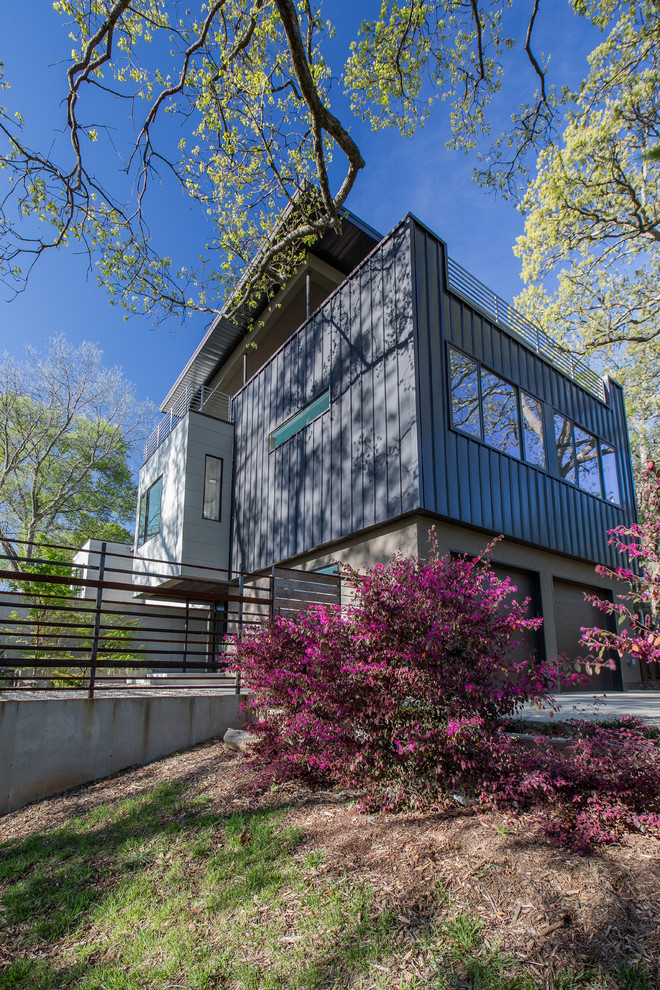 На фото: трехэтажный, коричневый дом среднего размера в современном стиле с облицовкой из металла и плоской крышей