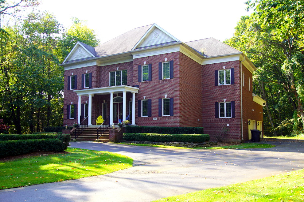 Exemple d'une façade de maison rouge chic en brique à un étage avec un toit à quatre pans et un toit en shingle.