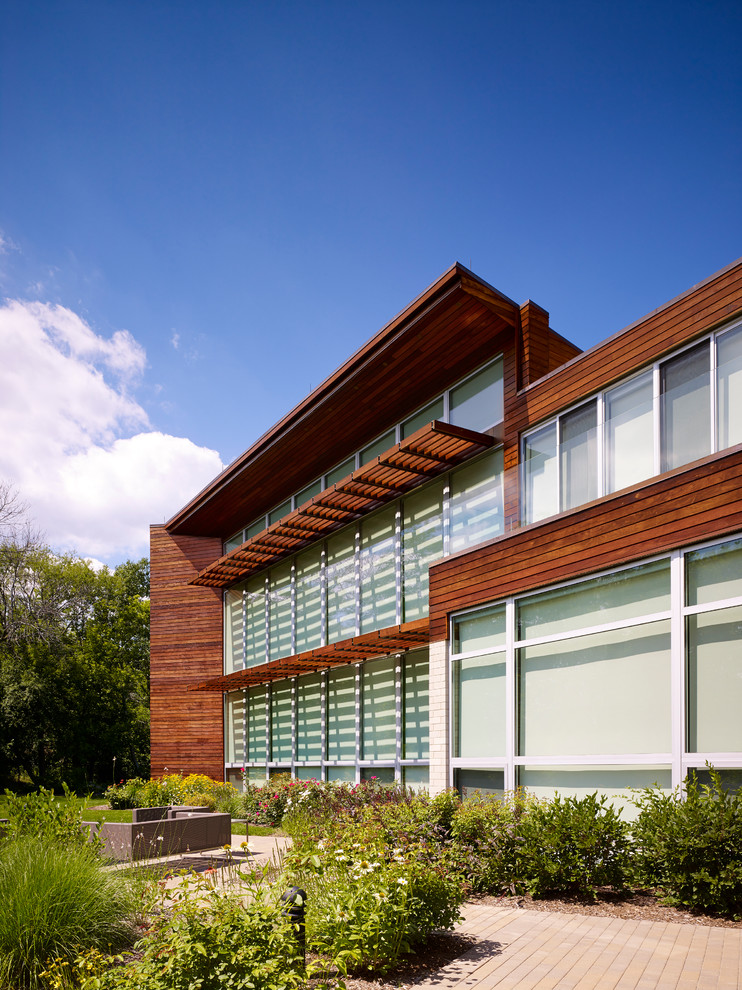 Réalisation d'une très grande façade de maison multicolore design en bois à un étage avec un toit plat.