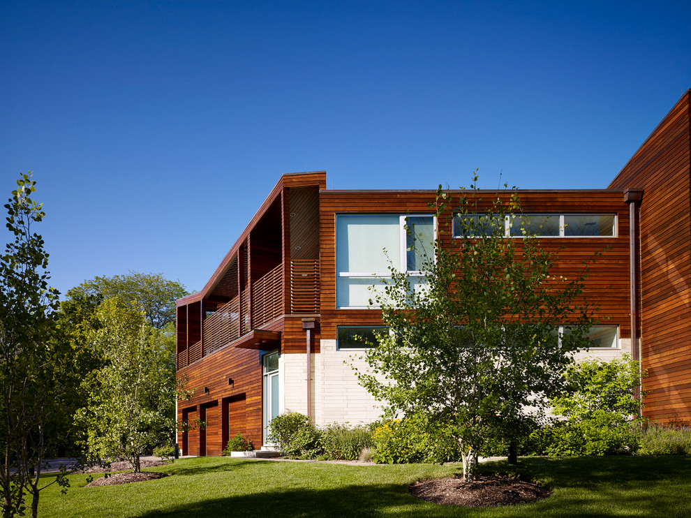 На фото: огромный, двухэтажный, деревянный, разноцветный частный загородный дом в современном стиле с плоской крышей
