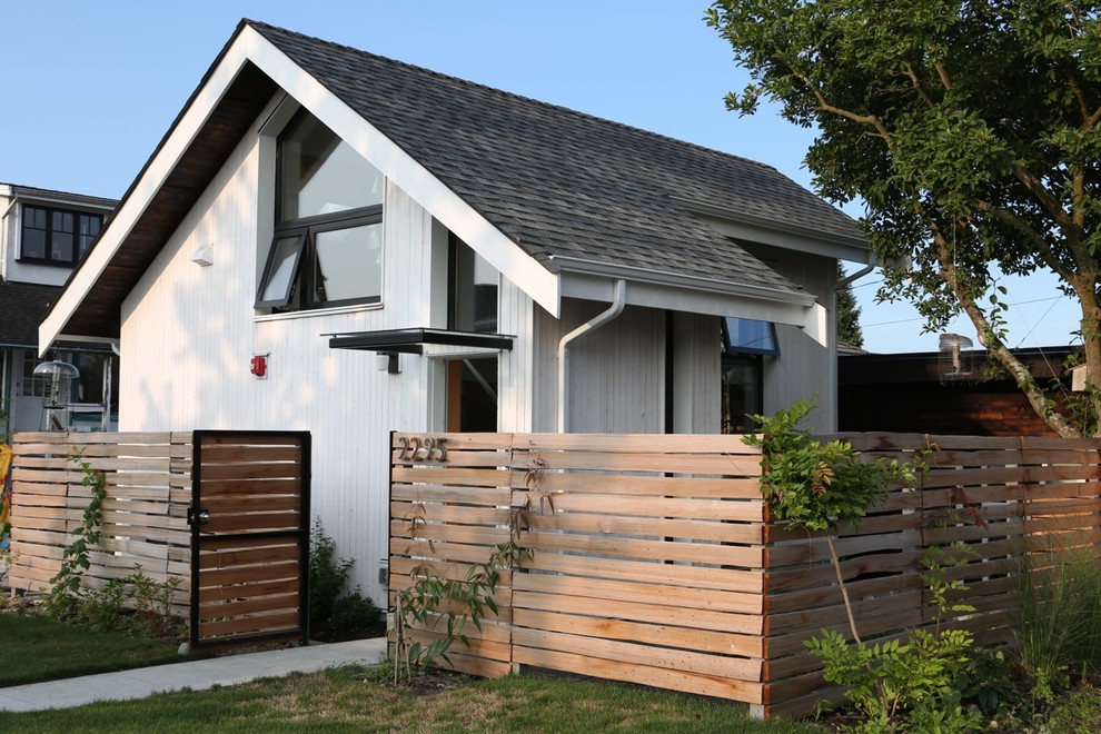 This is an example of a white contemporary two floor house exterior in Vancouver with wood cladding.