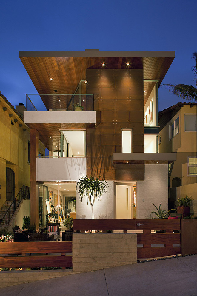 Foto della facciata di una casa contemporanea a tre piani di medie dimensioni con terreno in pendenza