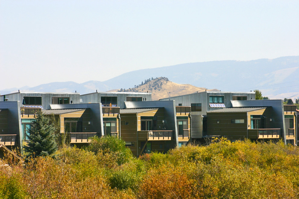 Dreistöckiges, Geräumiges Modernes Reihenhaus mit Mix-Fassade, grauer Fassadenfarbe, Flachdach und Blechdach in Sonstige