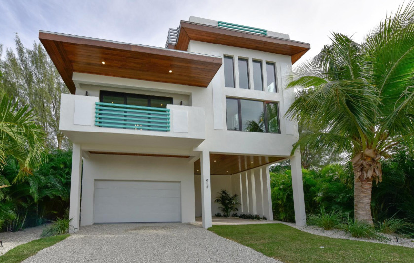 This is an example of a large and white contemporary house exterior in Tampa with three floors.