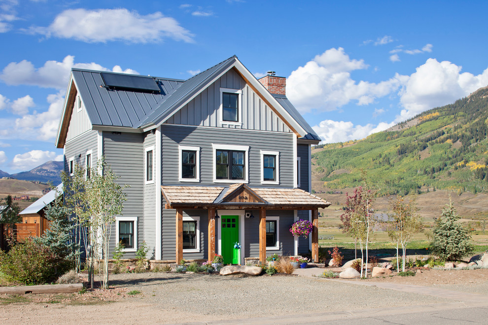 Diseño de fachada gris rural de tres plantas con tejado a dos aguas
