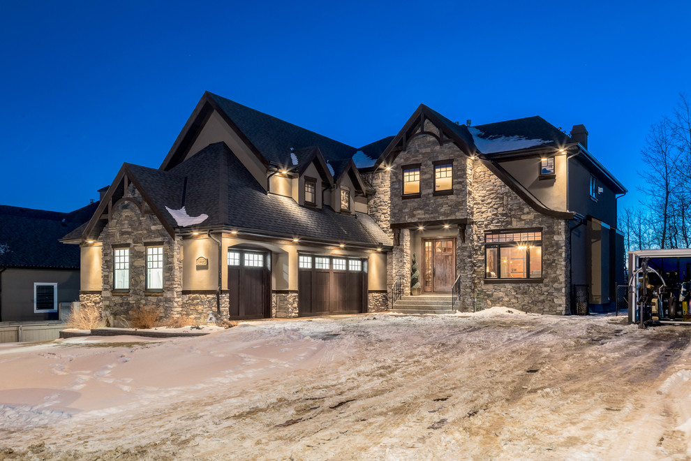 Photo of an expansive and gey traditional two floor house exterior in Calgary with stone cladding.