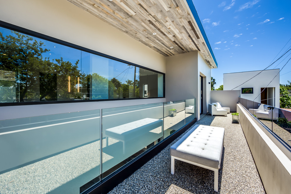 Example of a large minimalist gray two-story glass flat roof design in Los Angeles