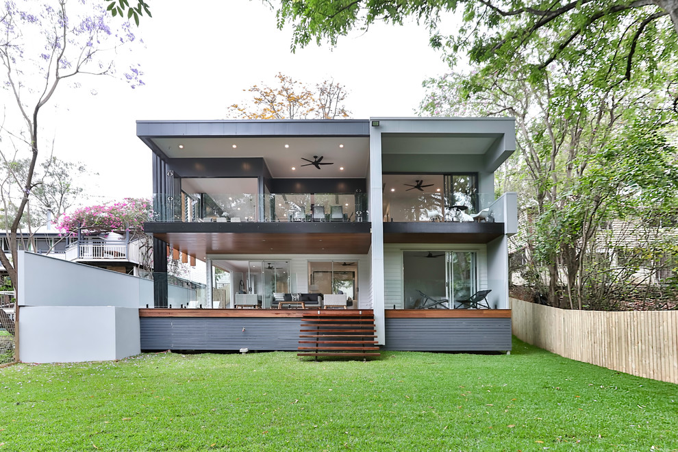 Inspiration för ett funkis grått hus, med två våningar, vinylfasad och platt tak