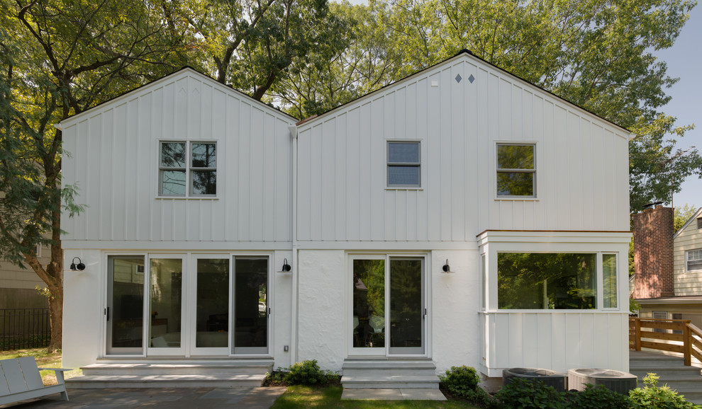 Mittelgroßes, Zweistöckiges Modernes Haus mit Mix-Fassade, weißer Fassadenfarbe und Satteldach in New York