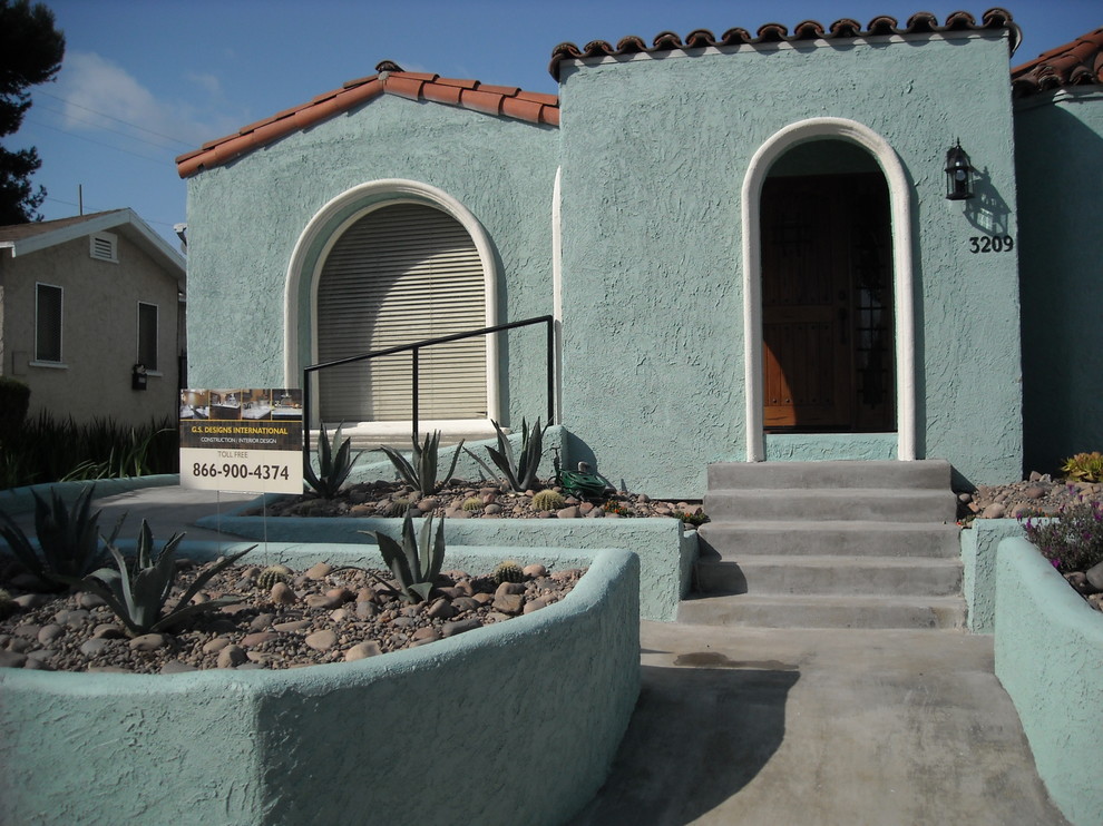 Exempel på ett litet amerikanskt blått hus, med allt i ett plan, stuckatur och tak med takplattor