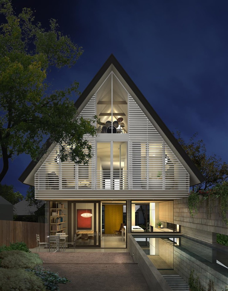На фото: трехэтажный, белый дом в современном стиле с двускатной крышей с