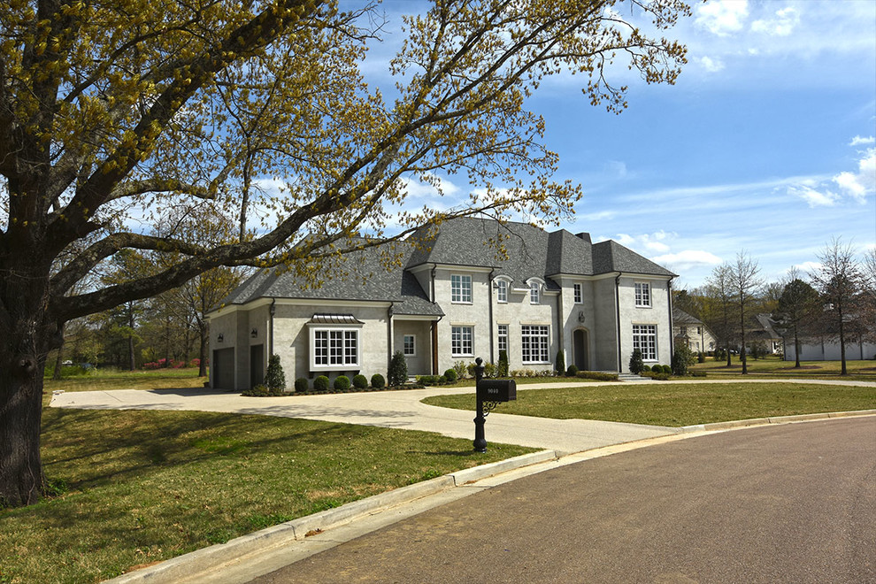 Mid-sized transitional gray two-story stucco house exterior idea in Other with a hip roof and a shingle roof