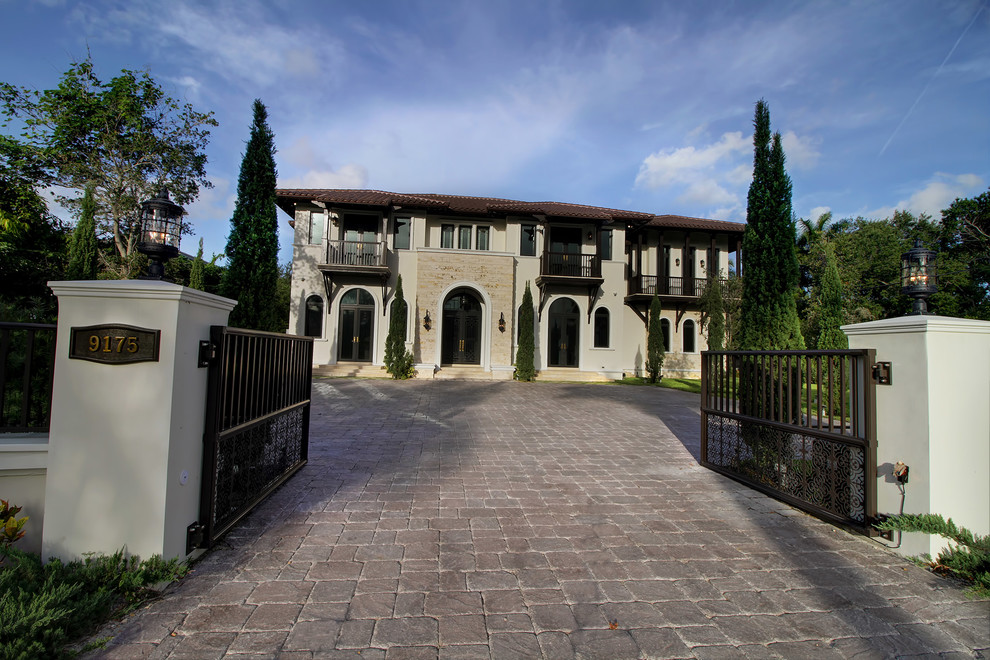 Example of a large tuscan white two-story stucco house exterior design in Miami