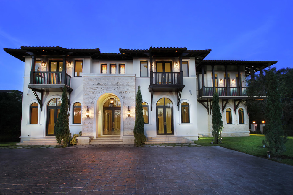 Large tuscan white two-story stucco house exterior photo in Miami