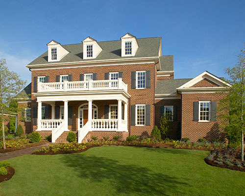 Пример оригинального дизайна: огромный, двухэтажный, кирпичный, красный дом в классическом стиле с двускатной крышей