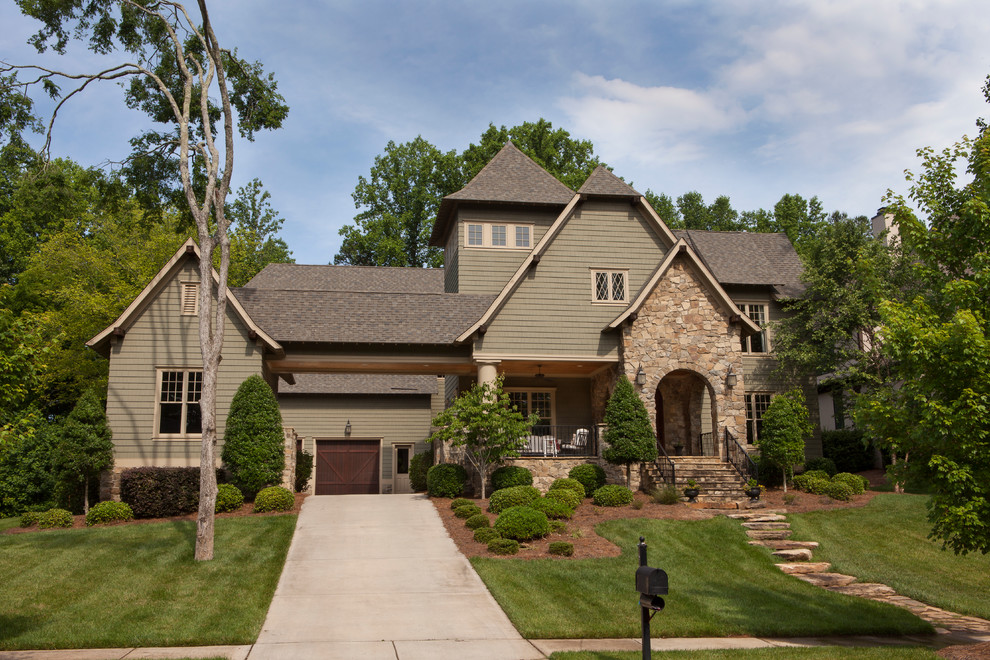 Large and brown traditional house exterior in Charlotte with three floors, wood cladding and a half-hip roof.