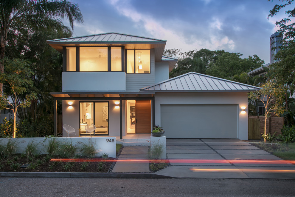 Imagen de fachada de casa gris contemporánea de tamaño medio de dos plantas con revestimientos combinados, tejado a cuatro aguas y tejado de metal