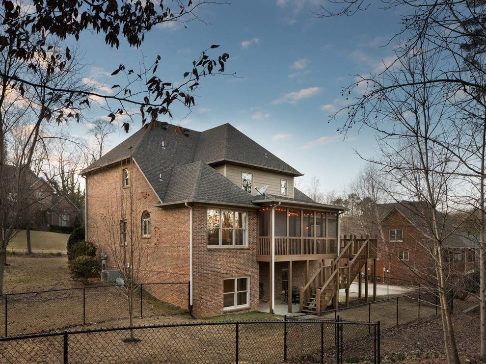 На фото: трехэтажный, кирпичный, коричневый дом среднего размера в классическом стиле с двускатной крышей