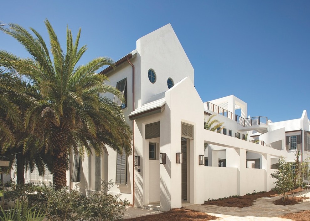 Diseño de fachada de casa blanca costera grande con revestimiento de estuco