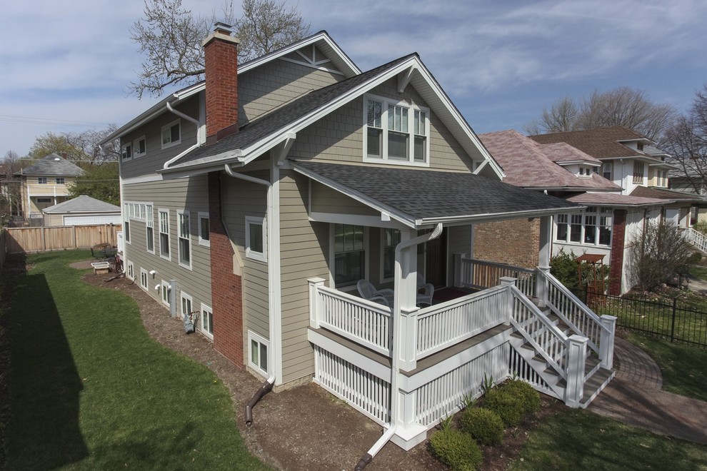 Esempio della facciata di una casa beige country a due piani di medie dimensioni con rivestimento con lastre in cemento