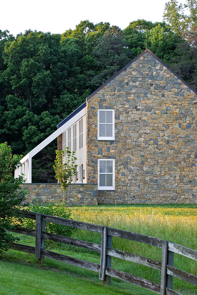 Ispirazione per la facciata di una casa fienile ristrutturato country a due piani con rivestimento in pietra e tetto a capanna