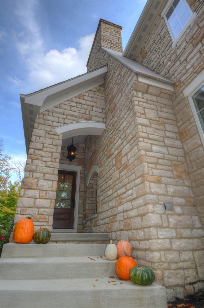 Idee per la facciata di una casa beige classica a due piani di medie dimensioni con rivestimento in pietra e tetto a capanna