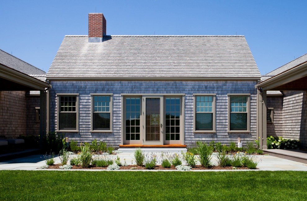 This is an example of a classic house exterior in Boston with wood cladding, a pitched roof and a shingle roof.