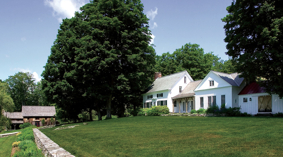 Immagine della facciata di una casa grande bianca country a due piani con rivestimento in legno e tetto a capanna