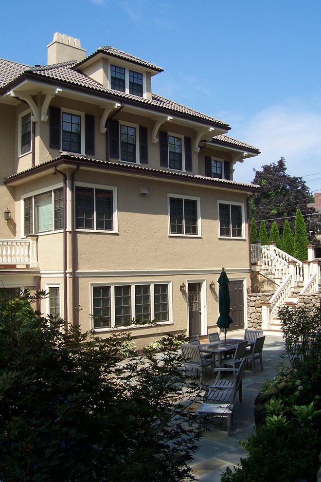 Immagine della facciata di una casa ampia beige mediterranea a tre piani con rivestimento in stucco