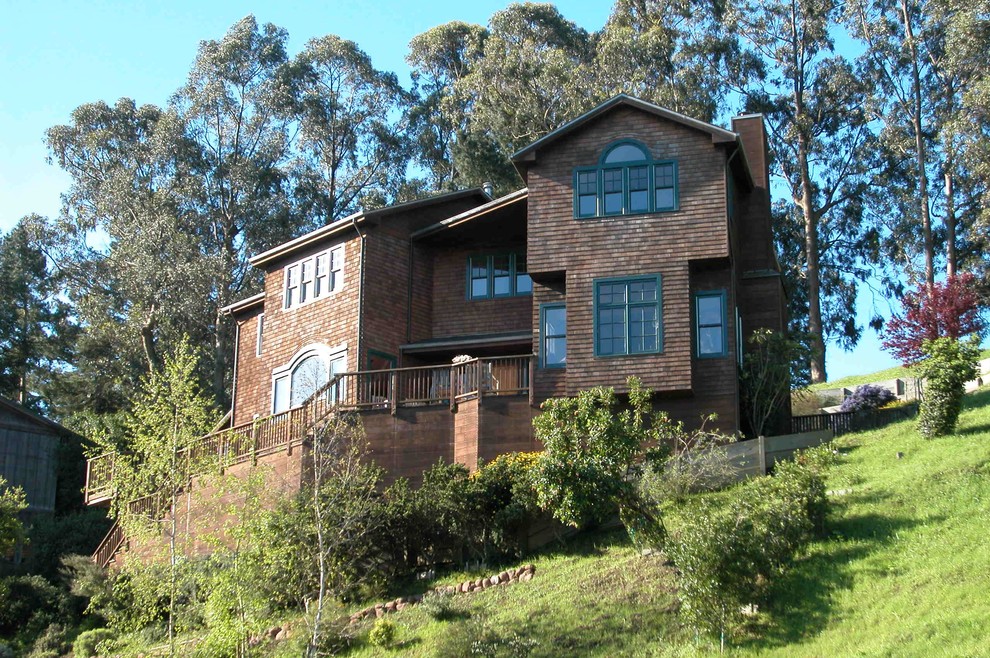 Aménagement d'une grande façade de maison marron craftsman en bois à un étage.