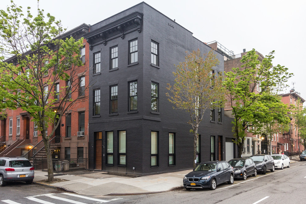 Geräumiges, Dreistöckiges Modernes Reihenhaus mit Backsteinfassade, schwarzer Fassadenfarbe, Flachdach und Misch-Dachdeckung in New York