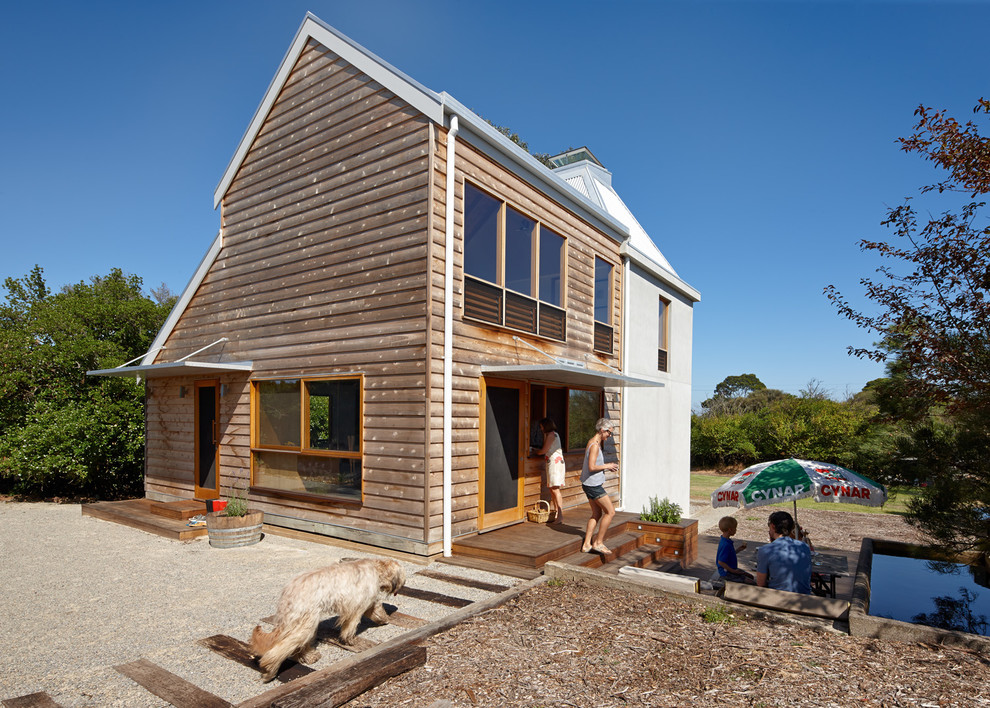 Foto della facciata di una casa piccola marrone contemporanea a due piani con rivestimento in legno e tetto a capanna