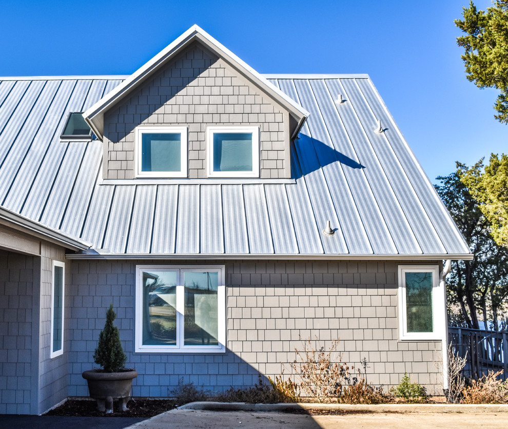 Modelo de fachada de casa beige de estilo de casa de campo grande de dos plantas con revestimiento de madera, tejado a dos aguas y tejado de metal