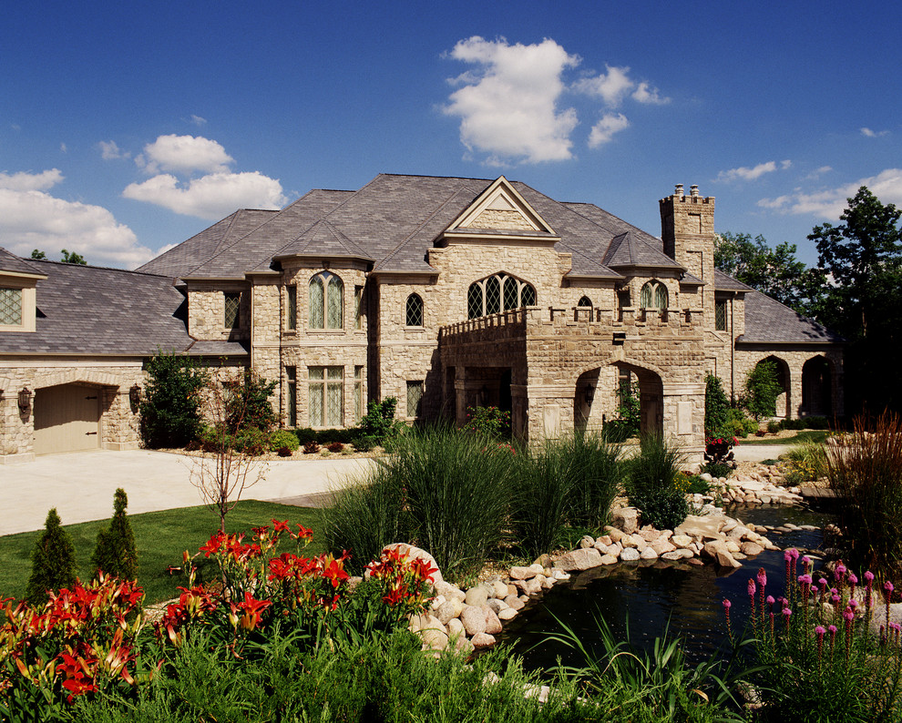 Example of a huge tuscan beige three-story stone exterior home design in Cedar Rapids
