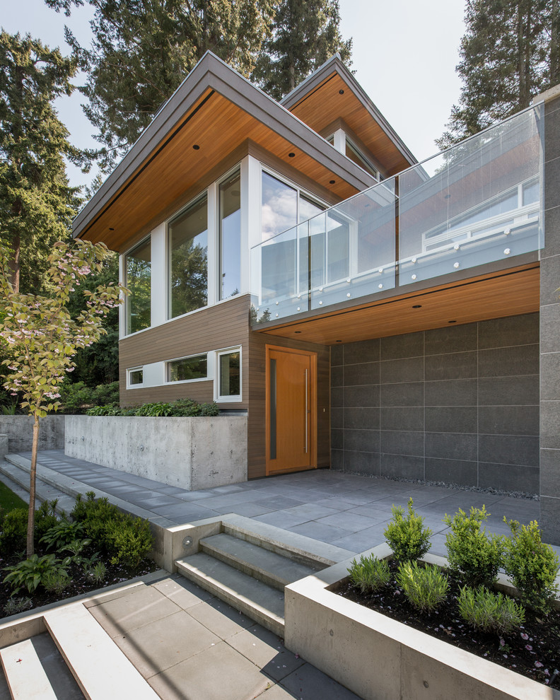 Diseño de fachada de casa gris minimalista grande de dos plantas con revestimientos combinados y tejado plano