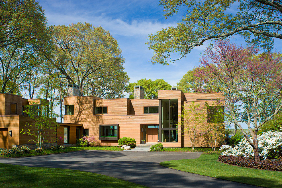 Immagine della facciata di una casa ampia marrone contemporanea a due piani con rivestimento in legno e tetto piano
