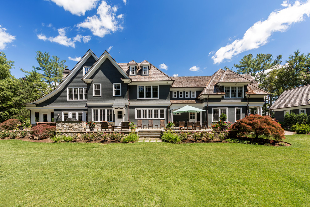Photo of a large traditional detached house in New York with three floors, wood cladding and a shingle roof.