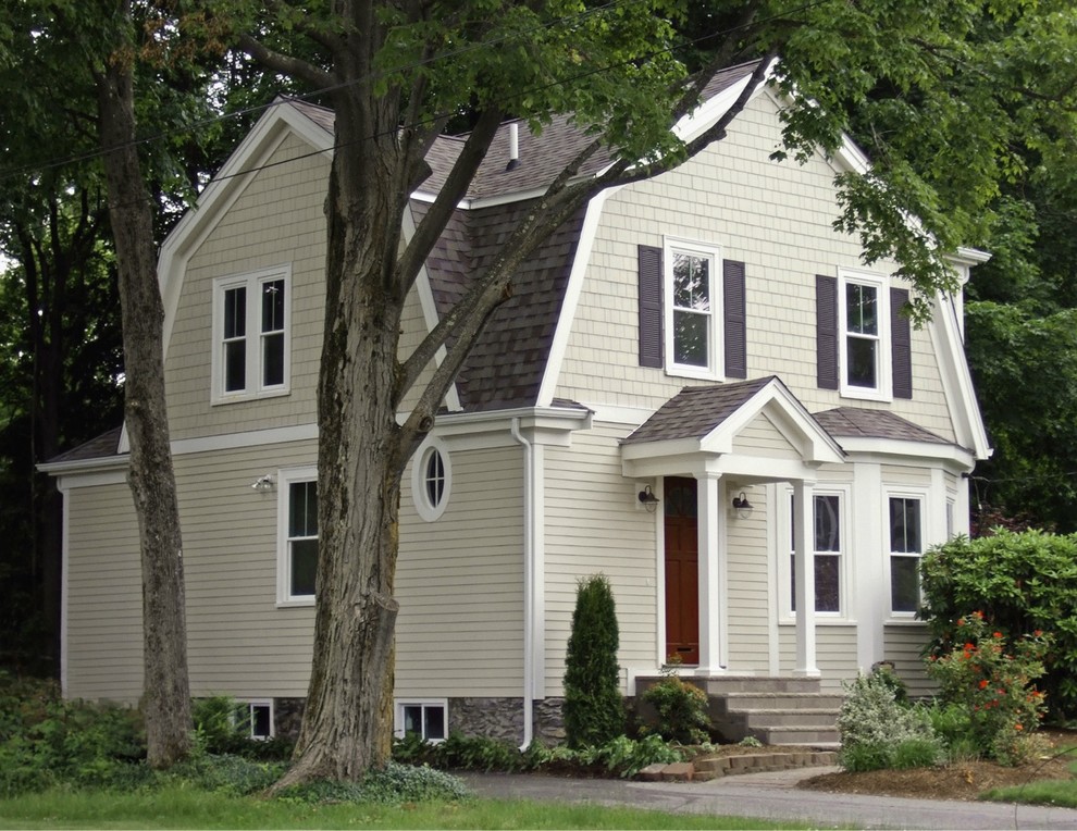 На фото: маленький, двухэтажный, бежевый дом в викторианском стиле с облицовкой из ЦСП и мансардной крышей для на участке и в саду с