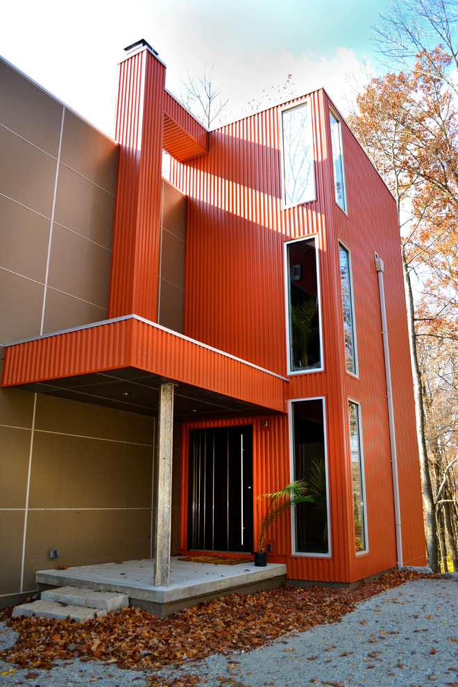 Esempio della facciata di una casa ampia marrone contemporanea a tre piani con rivestimento in metallo e tetto piano
