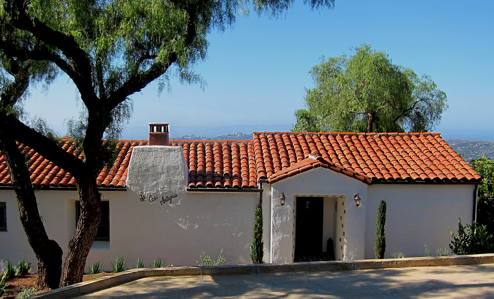Mid-sized mediterranean white one-story stucco house exterior idea in Santa Barbara with a clipped gable roof and a tile roof