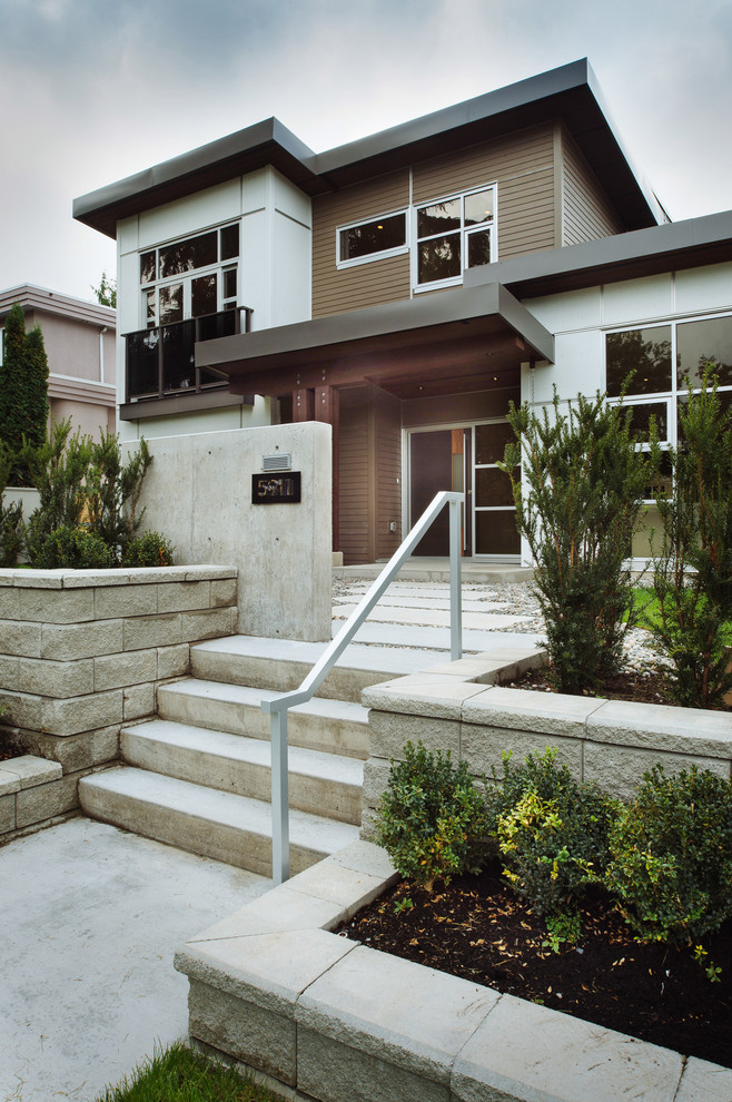Large modern gray three-story mixed siding flat roof idea in Vancouver