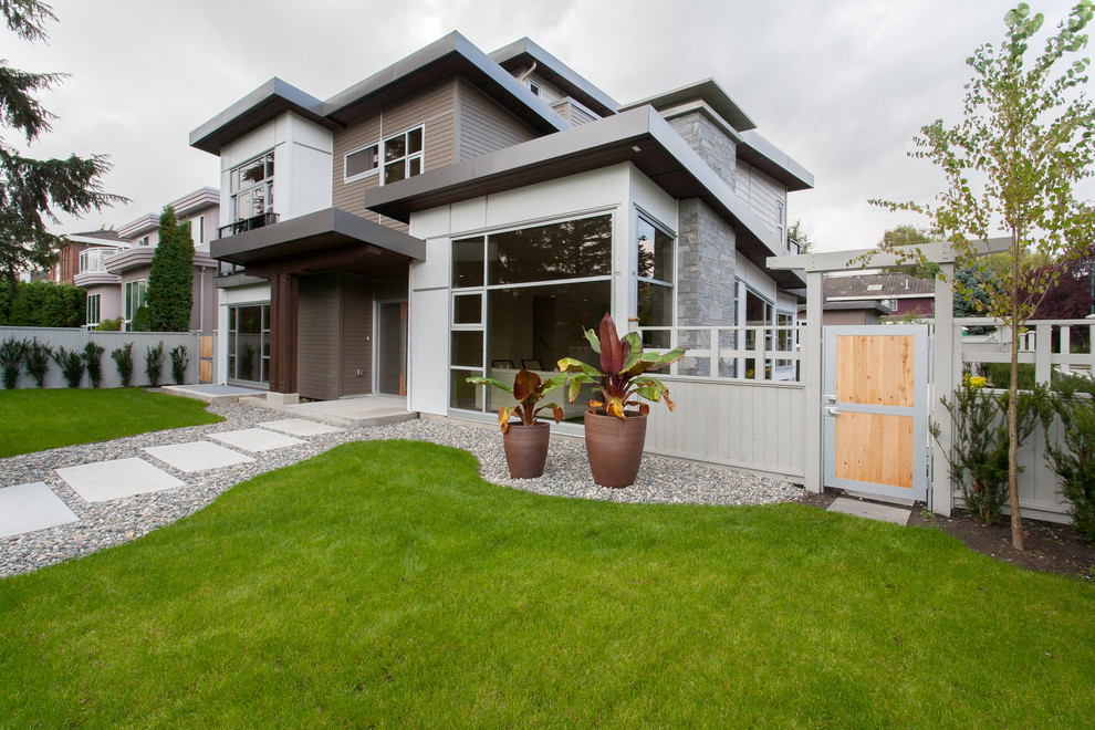 Example of a large minimalist gray three-story mixed siding flat roof design in Vancouver