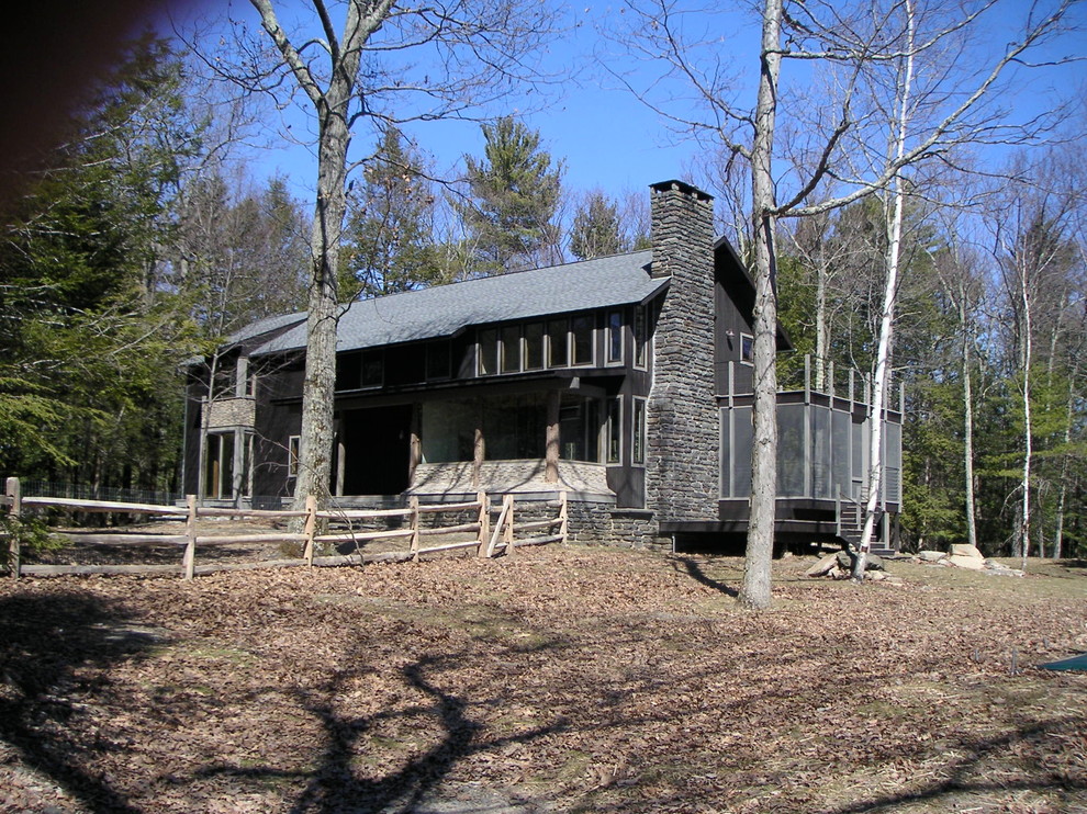 Modelo de fachada de casa marrón rural grande de dos plantas con revestimiento de madera y tejado a dos aguas