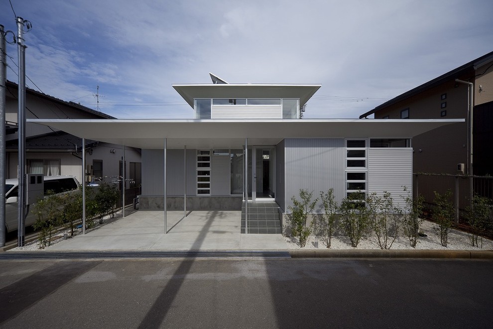 Aménagement d'une façade de maison grise contemporaine avec un toit plat.