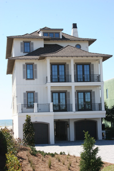 Идея дизайна: большой, трехэтажный, бежевый дом в морском стиле с комбинированной облицовкой