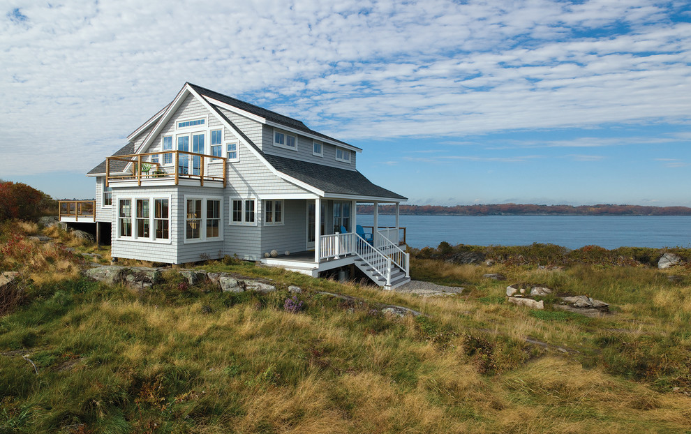 Cette photo montre une façade de maison grise bord de mer à un étage.