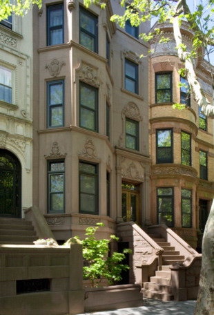 This is an example of a large and beige classic render flat in New York with three floors, a pitched roof and a shingle roof.